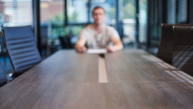 Image of an employee in office conference room.