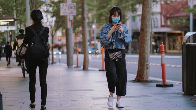 Image of woman walking on Sydney street with face mask