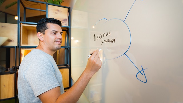 Image of a man writing on a whiteboard