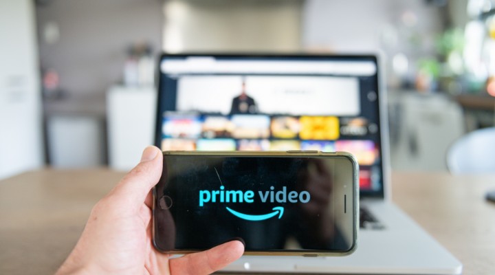 a picture of someone holding a video with prime video on the screen