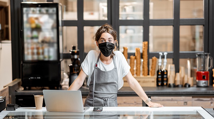 Image of a woman wearing a face mask at a cafe