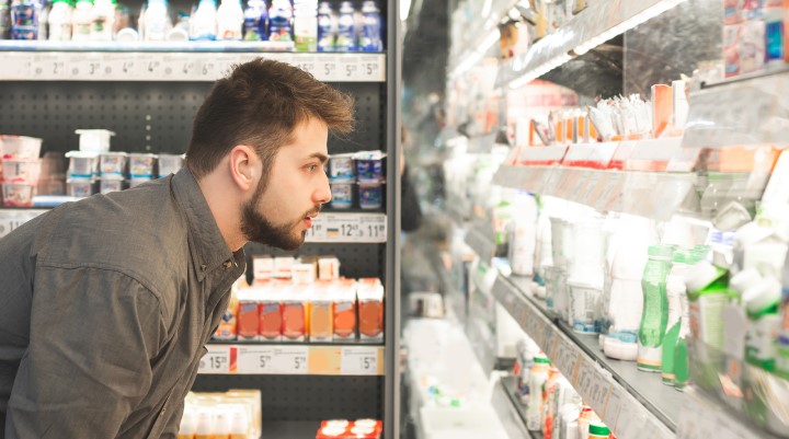 man browsing milk at grocery store