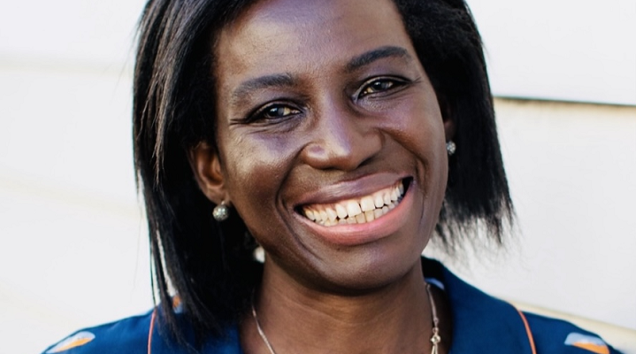 Close-up of Baresop founder Prisca Ongonga-Daehn, a Black woman with chin length hair wearing a blue patterned blouse.