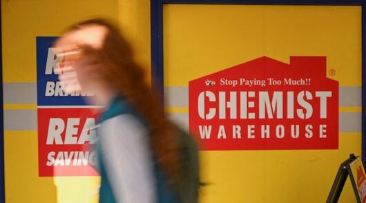 A person walking past a Chemist Warehouse store