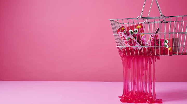 A Dusk campaign image of a wire shopping basket filled with Allens lollies against hot pink background.