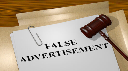 Text 'false advertising' on documents with a gavel.