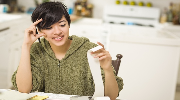 Image of woman looking at bills.
