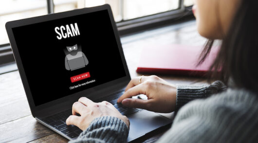 Image of laptop with a scam alert.