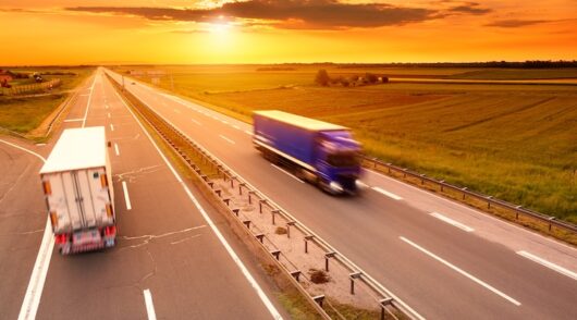 Blue and white truck in motion blur on the highway at sunset