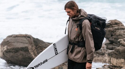 Image of man holding surfboard.
