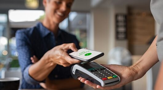 Woman paying bill through smartphone using NFC technology