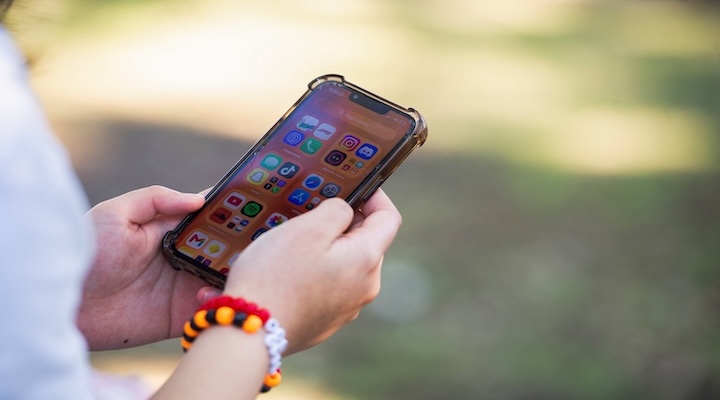 An Australian teen holding a mobile phone