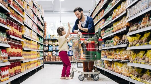 Young man and daughter are shopping in grocery store.
