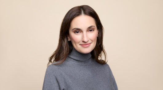 Studs CEO Anna Harman in a grey sweater against a taupe background.