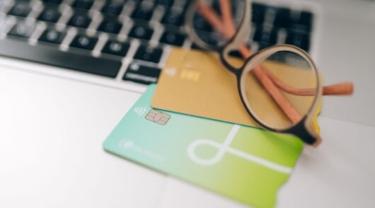 Close-up of eyeglasses and loyalty cards on a laptop