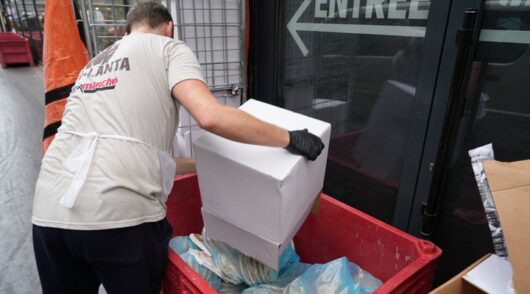 Supermarket worker discards food.